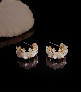 Detail van Franse stijl C-vormige oorbellen met witte bloemen en glinsterende strass