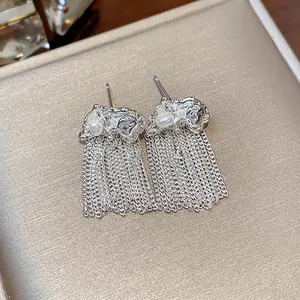 Elegant silver-colored crinkled chain tassel earrings with pearl detail on textured box.