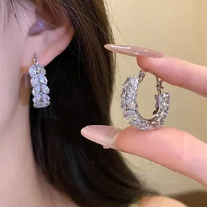 Detail view of silver hoop earrings with marquise-cut zircon in a wheat ear pattern.