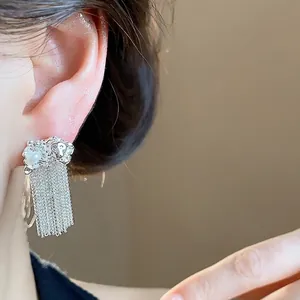 Elegant silver wrinkled chain tassel drop earrings with pearl detail worn on ear