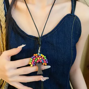 Gros plan détaillé d'un pendentif arbre ethnique avec des perles en bois colorées.