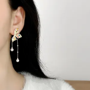 Detail view of sweet floral tassel earrings with colorful polka dots and pearl accents.