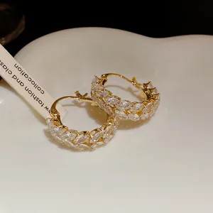 Elegant detail view of vintage gold hoop earrings with marquise zircon wheat patterns