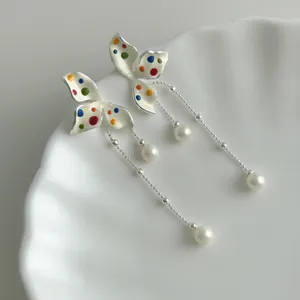 Detailed view of sweet flower earrings with colorful polka dots and pearl tassels