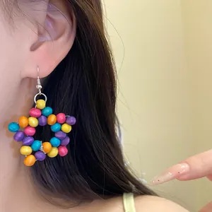 Gros plan détaillé de boucles d'oreilles en perles de bois colorées en forme d'étoile