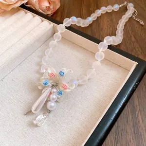 Gros plan du collier en perles de cristal avec pendentif fleur orné de roses délicates.