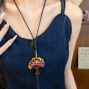 Gros plan d'un collier pendentif arbre en perles de bois colorées sur cordon en cuir