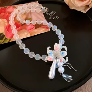 Vue détaillée élégante d'un pendentif perle floral sur collier de perles blanches