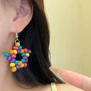 Gros plan de boucles d'oreilles étoile en perles de bois colorées de style bohème