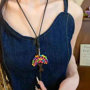 Vue détaillée du collier de style ethnique avec pendentif arbre en perles de bois colorées