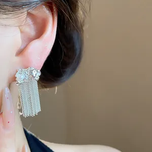 Close-up detail of silver pleated chain tassel earrings with pearl accent for women
