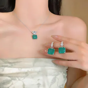 Détail d'un élégant ensemble de collier et boucles d'oreilles en zircon vert carré
