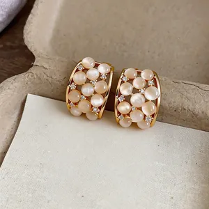 Luxurious 18k gold plated stud earrings featuring milky cat eye stones and sparkling zircons