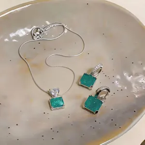 Vue détaillée de l'ensemble collier avec pendentif vert émeraude et boucles d'oreilles