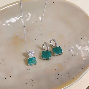 Vue détaillée de l'ensemble collier et boucles d'oreilles avec pendentif zircon vert