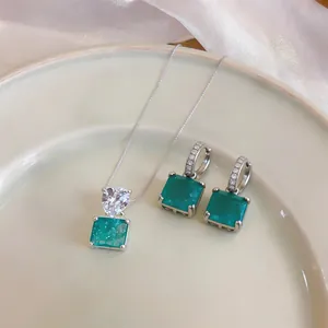 Vue détaillée d'un collier pendentif carré vert émeraude élégant et boucles d'oreilles