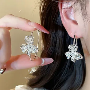 Elegant silver needle earrings with hollow flower design and sparkling cubic zirconia