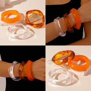 Detail view of irregular wide resin bangles in retro amber and orange shades