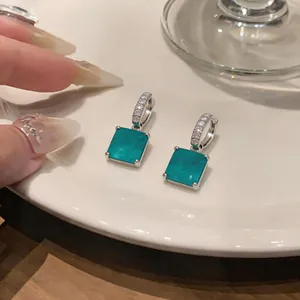 Détail de boucles d'oreilles carrées de style français avec zircon et pendentifs bleus