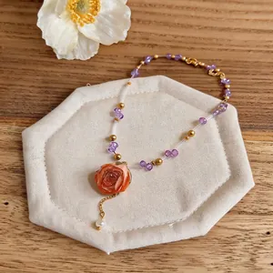 Elegant beaded necklace featuring a vibrant preserved rose pendant and pearl detail.