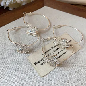 Detailed view of hollow butterfly hoop earrings with sparkling colorful zircon inlay