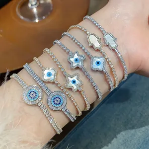 Detailed close-up of 18k gold plated tennis bracelets with Hamsa and Evil Eye charms