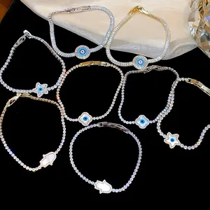 Detail of elegant 18k gold plated zircon bracelets featuring star and evil eye charms.