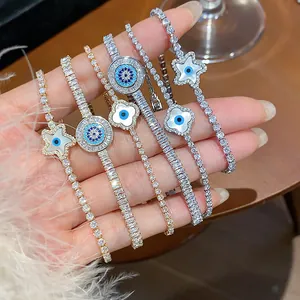 Detailed view of gold and silver evil eye tennis bracelets with star and clover charms