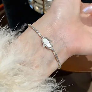 Close-up of a sparkling 18k gold plated zircon Hamsa hand bracelet with white inlay