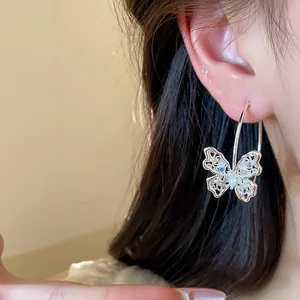Close-up view of elegant zircon hollow butterfly hoop earrings worn by a model