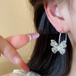 Macro view of hollow butterfly hoop earrings with sparkling colorful cubic zirconia.