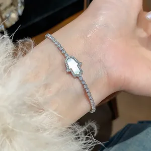 Close-up of elegant 18k gold plated Hamsa hand bracelet with white inlay and crystals