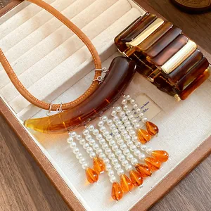 Vista dettagliata della collana in perle acriliche retrò e del bracciale coordinato in box