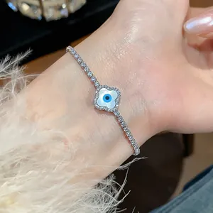Close-up detail of a zircon four-leaf clover bracelet with an evil eye motif.