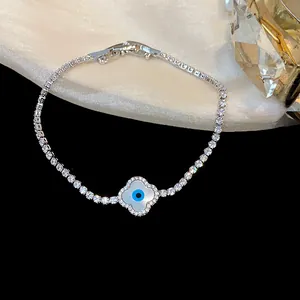 Detail view of 18k gold plated zircon bracelet with clover evil eye motif.