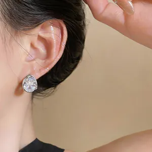 Primo piano di un elegante orecchino a bottone in zircone ovale, finitura argento