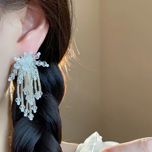 Detailed view of elegant glass flower tassel earrings showing delicate beadwork on ear
