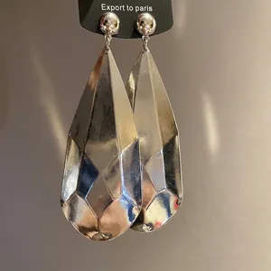 Pendientes de lágrima metálica facetada en plata brillante con diseño minimalista