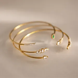 Macro shot of 18k gold plated stainless steel cuff bracelets with sparkling zircon accents.