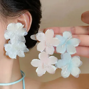Detailed view of elegant chiffon flower stud earrings with glass beads and silver pins.