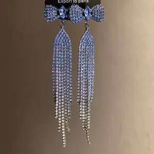 Detail of bowknot tassel earrings featuring sparkling rhinestones and blue stones