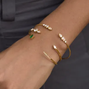 Close-up of 18k gold-plated stainless steel bangles with sparkling cubic zirconia on wrist.