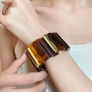 Bracciale rigido retrò stile Maillard in acrilico tartarugato e blocchi di metallo dorato.