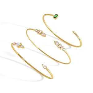 Set of three 18k gold plated stainless steel bangles with clear and green cubic zirconia