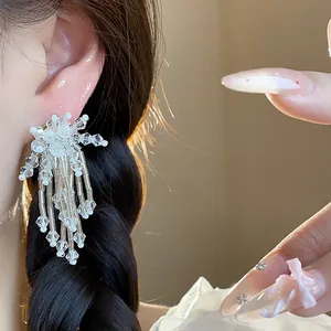 Close-up of elegant glass flower tassel earrings with shimmering white beads