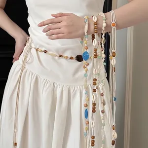 Bohemian multi-layer beaded waist chain with shells and wood beads on white dress