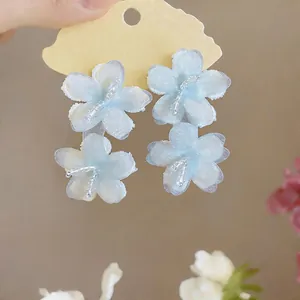 Detailed view of light blue chiffon flower earrings with delicate white glass beads