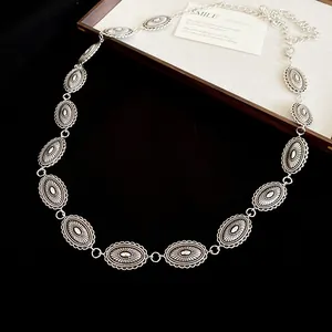 Detail view of a vintage silver ethnic style waist chain featuring oval relief links