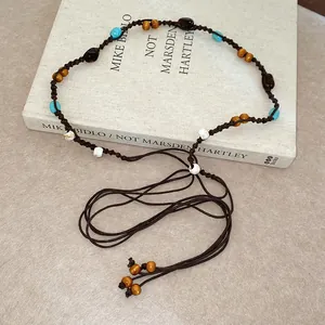Close-up detail of bohemian beaded waist chain featuring turquoise and wooden beads on cord