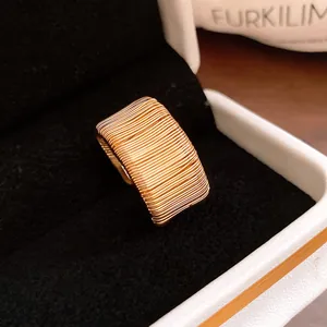 Macro view showing the detailed wire-wrapped texture of a vintage gold wide band ring